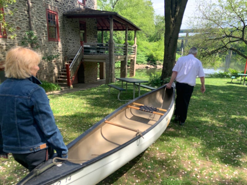 Canoe Club members carry a canoe to the river