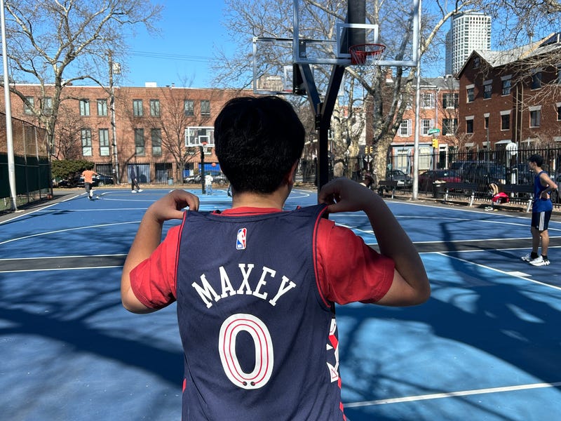 Eric, a ninth-grader from Chinatown, proudly displays the Tyrese Maxey jersey he got for Christmas.