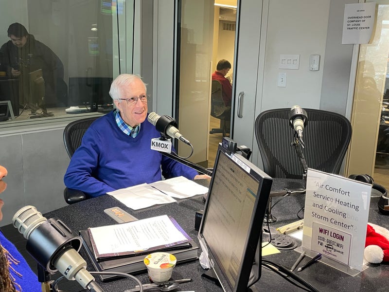Rick Hummel sits in KMOX studio. he is a white man with white hair and a blue sweater on