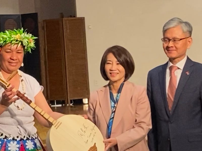 A representative from the Pacific island nation of Tuvalu (left) receives a moon guitar -- or yueqin -- from the magistrate of Pingtung County, Chou Chun-mi (center), along with ambassador James K.J. Lee of the Taipei Economic and Cultural Office in New York, on April 30, 2024.