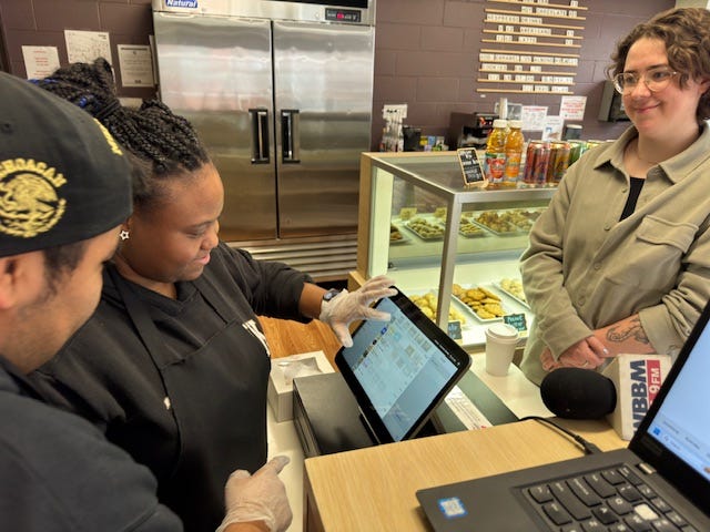 Gateway to Learning serving a customer at the bake shop.