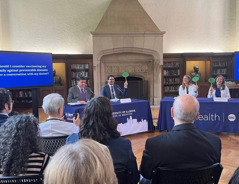 Illinois Governor J.B. Pritzker (left) asks questions during an "Ask Your Doctor" event at UIC School of Public Health. Other panelists, from left: Illinois Public Health Director Dr. Sameer Vohra, UChicago Medicine infectious disease expert Dr. Emily Landon, and Dr. Lynn Yee from the Society for Maternal-Fetal Medicine