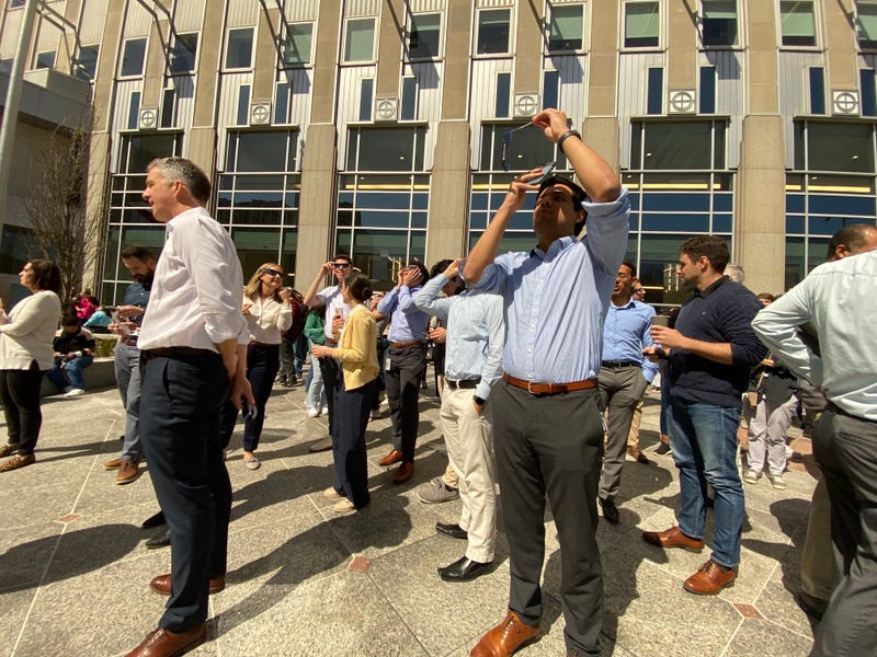 A man uses his eclipse glasses in an attempt to give his phone a filter and successfully capture Monday's eclipse.