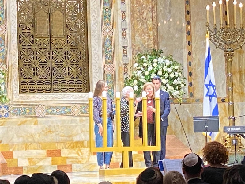 One of six Holocaust survivors take to the stage to light one candle, representing 1 million of the 6 million Jews who were killed in the Holocaust.