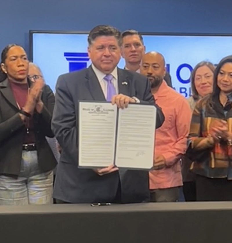 Illinois Governor J.B. Pritzker displays his signed executive order setting up the "Illinois Accountability Commission."