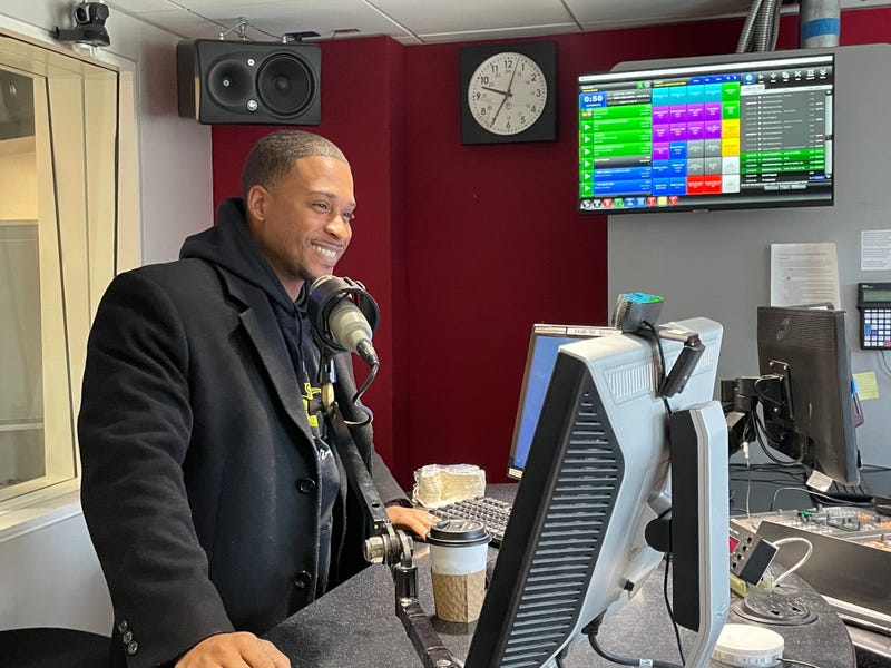 brandon williams speaks into a mic at kmox. he's a black man with short hair and a black wool coat.