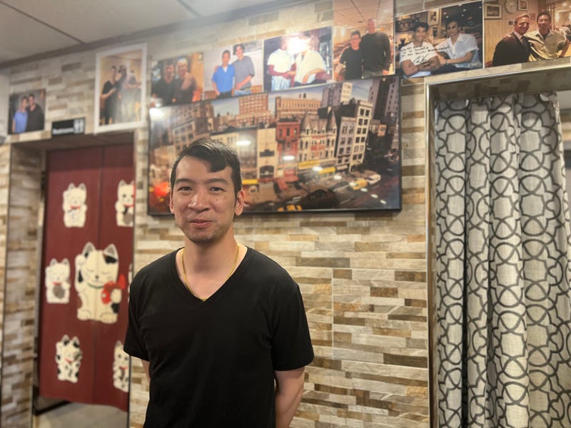 Richard Lam in front of his dad's storefront photo