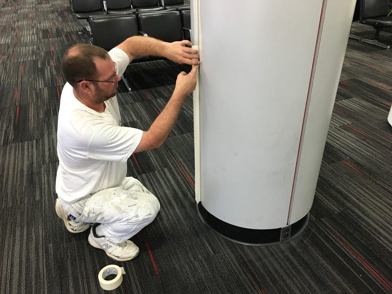 A worker in 2016 repaints parts of Lambert Airport's former concourse D from TWA red to Southwest blue in preparation for the space to become part of concourse E and Southwest's expansion.