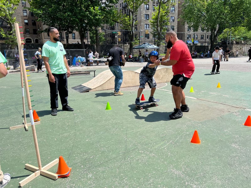 A father helping his son on the board for the first time