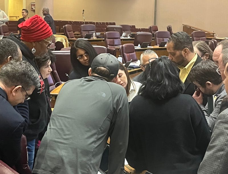 Supporters of Chicago's "alternate" budget plan huddle during a City Council committee hearing, December 17, 2025.