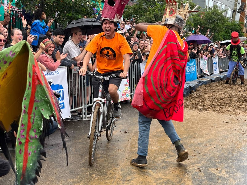 A man on a bike screams as he rides through the mud pit at the Kensington Derby.
