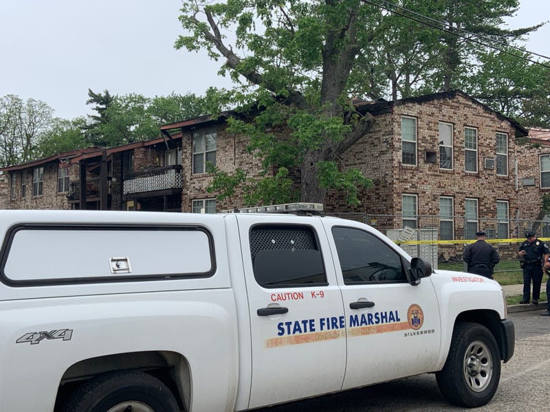Fire officials outside an apartment complex following a morning fire.