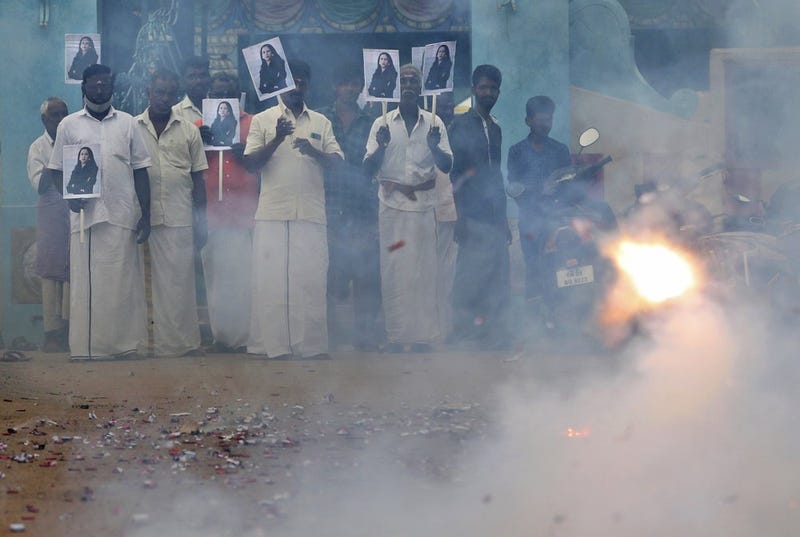 Villagers burst firecrackers and hold placards featuring U.S. Vice President-elect Kamala Harris ahead of her inauguration, in Thulasendrapuram, the hometown of Harris' maternal grandfather, south of Chennai, Tamil Nadu state, India, Wednesday, Jan. 20, 2021. A tiny, lush-green Indian village surrounded by rice paddy fields was beaming with joy Wednesday hours before its descendant, Kamala Harris, takes her oath of office and becomes the U.S. vice president. (