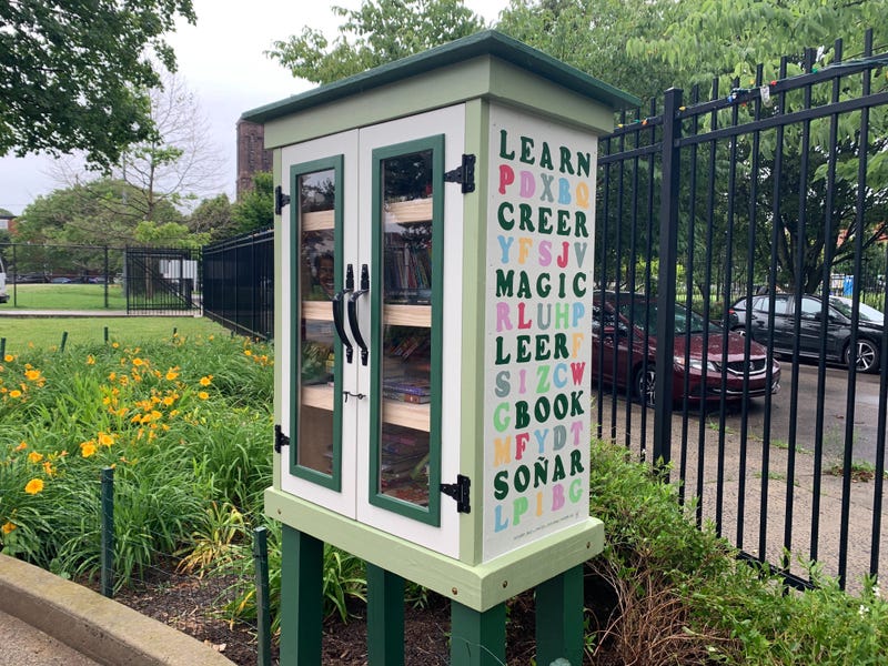 The side of the Little Free Library box in Spring Garden's Clemente Playground reads "Learn, Creer, Magic, Leer, Book, Soñar."