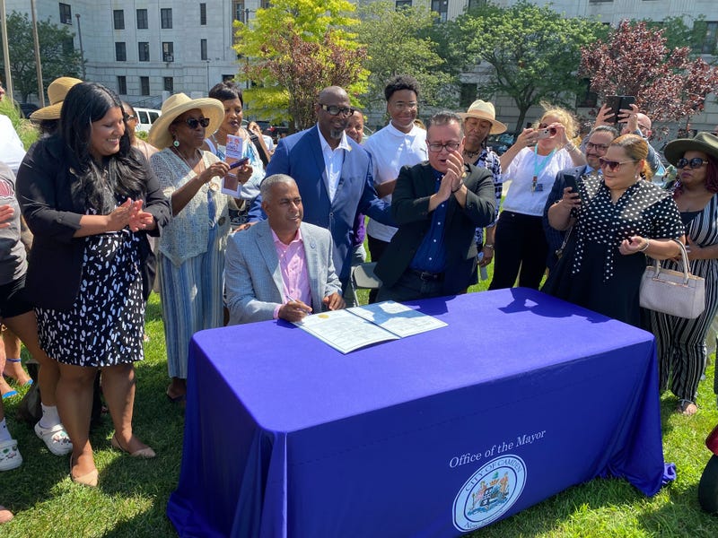 Camden Mayor Vic Carstarphen and City Council President Angel Fuentes sign the ordinance into law outside City Hall.