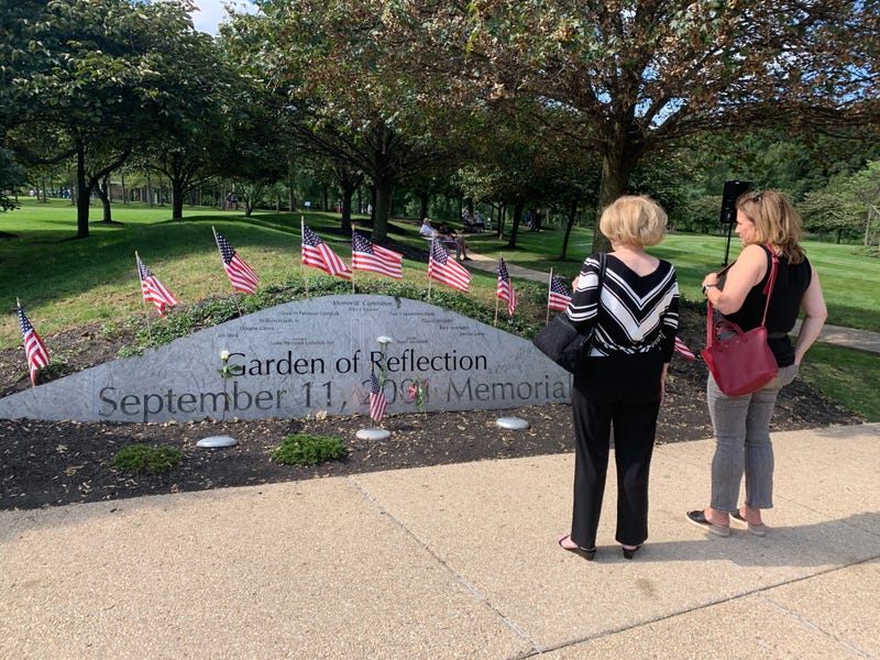 Two people look at the sign for the Garden of Reflection.