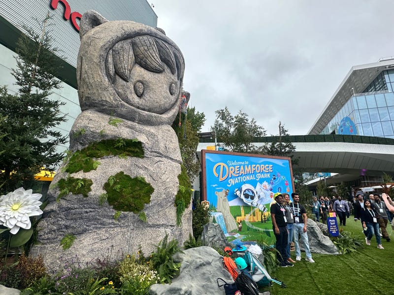 Attendees pose in front of a "Welcome to Dreamforce National Park" sign in a faux outdoor setting at Moscone Center.