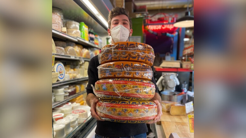 Jake Heller holding his wheels of cheese.
