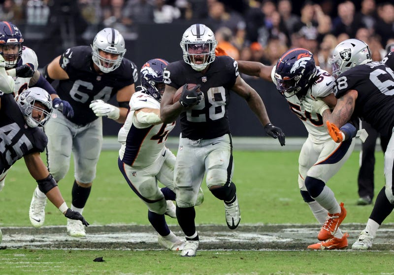 Raiders' RB Josh Jacobs bursts through a hole against the Denver Broncos