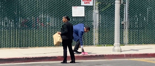 LAPD investigators pick up pink shoes belong to child that was hit by a car near Hancock park Elementary School on Tuesday.