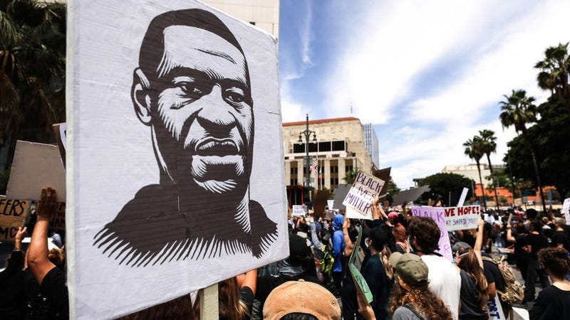 A protester holds a sign with an image of George Floyd during a peaceful demonstration over Floyd’s death outside LAPD headquarters on June 2, 2020 in Los Angeles, California. 