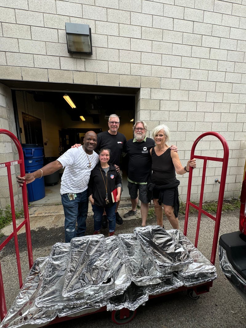 Maria Brunner (right) poses with Musically Fed volunteers as they load unused meals to donate. The team will be at Lollapalooza this year to deliver excess catering food to families in need. 