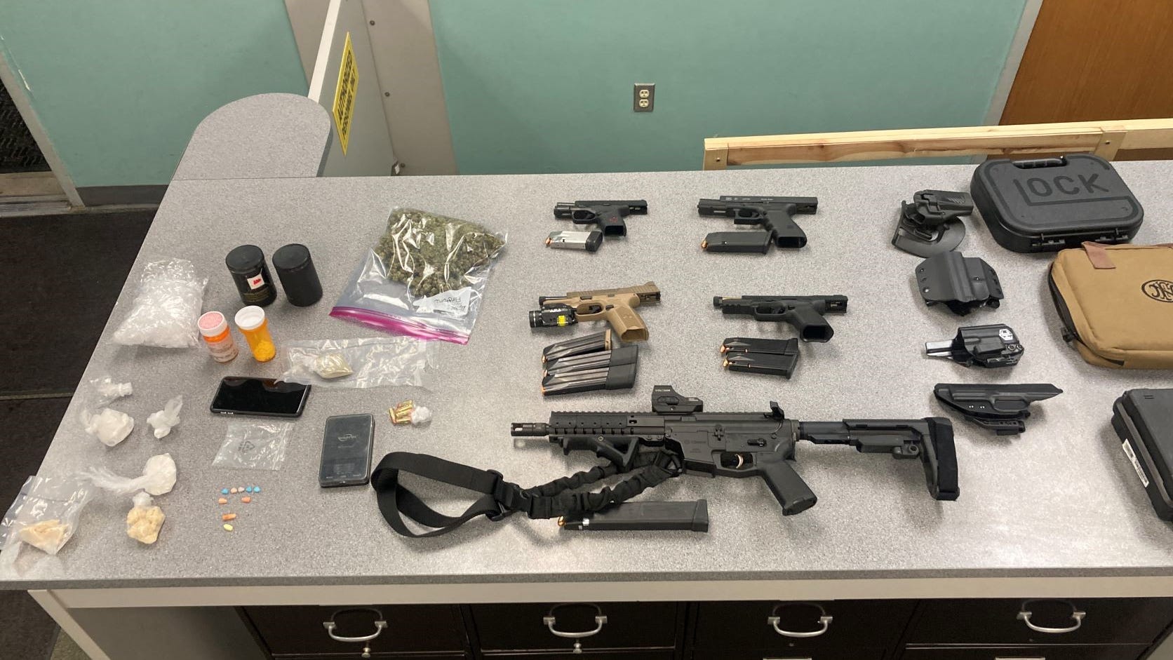 Lansing-area man arrested for possession of drugs, more than a dozen guns