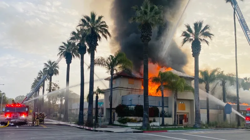 fire trucks blast water at burning building