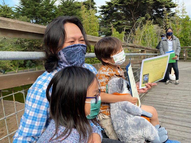 The boy who found Maki, the stolen lemur, and his father and sister relax at the San Francisco Zoo.