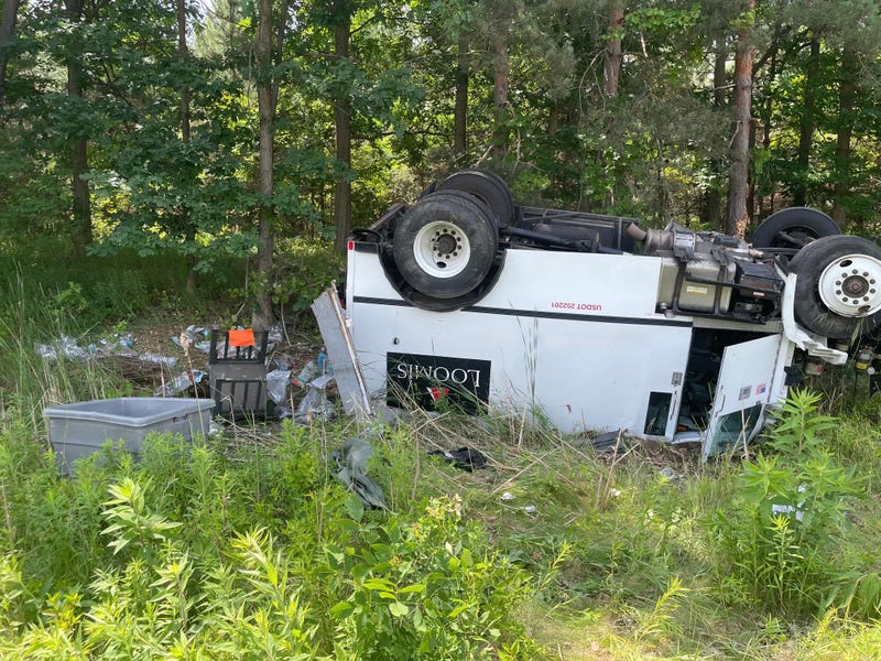 Loomis armored truck overturned with debris scattered in ditch