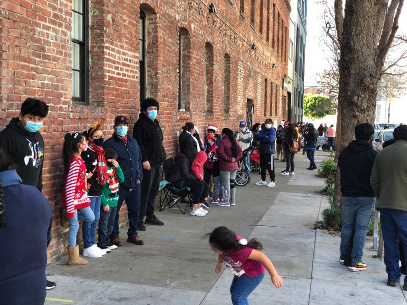 Families line up at the Mission Food Hub to pick up their free toys.