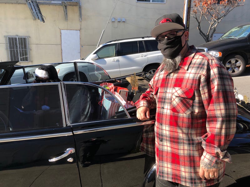 A member of the lowrider club volunteers to hand out toys to families in need.