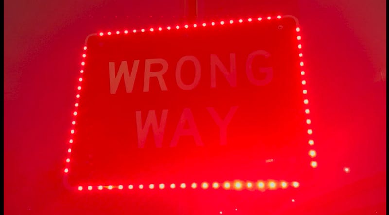 Flashing red lights on wrong way sign