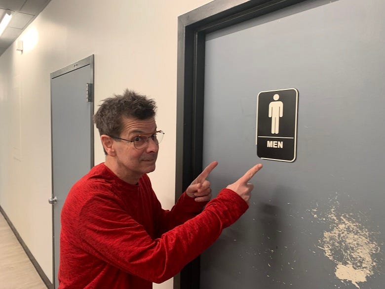 Rocky pointing to the KRZ Men's Room sign