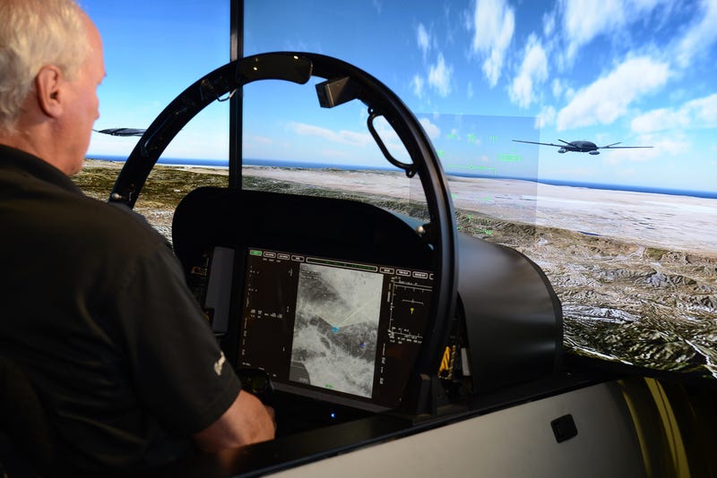 A simulated F/A-18 Super Hornet interacts with a simulated MQ-25.
