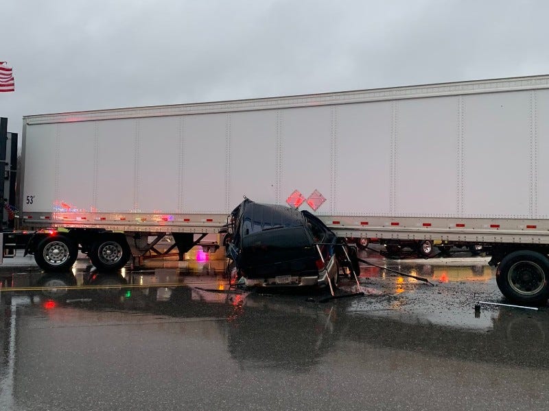 Car underneath semi truck