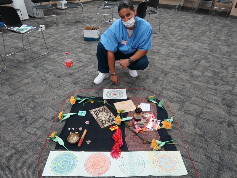 Man incarcerated at Soledad State Prison poses with centerpiece as part of Ahimsa Collective Empathize program