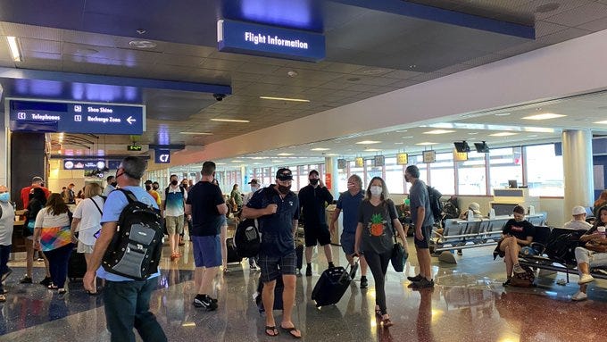 Travelers head through a concourse at McCarran International Airport