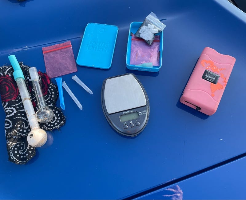 Pink taser, drug paraphernalia and scale on police car