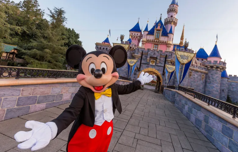 ANAHEIM, CA - AUGUST 27: Mickey Mouse poses in front of Sleeping Beauty Castle at Disneyland Park on August 27, 2019 in Anaheim, California. Disneyland plans to reopen on April 30, 2021.