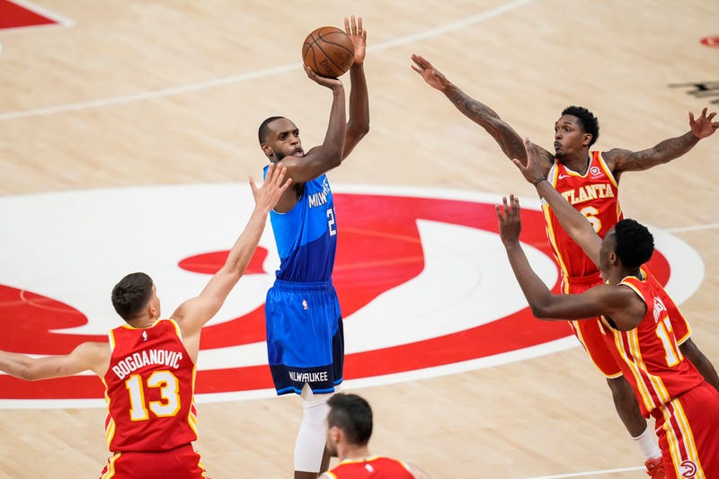 Jun 27, 2021; Atlanta, Georgia, USA; Milwaukee Bucks forward Khris Middleton (22) shoots a three point shot through four Atlanta Hawks players during the second half during game three of the Eastern Conference Finals for the 2021 NBA Playoffs at State Farm Arena. Mandatory Credit: Dale Zanine-USA TODAY Sports