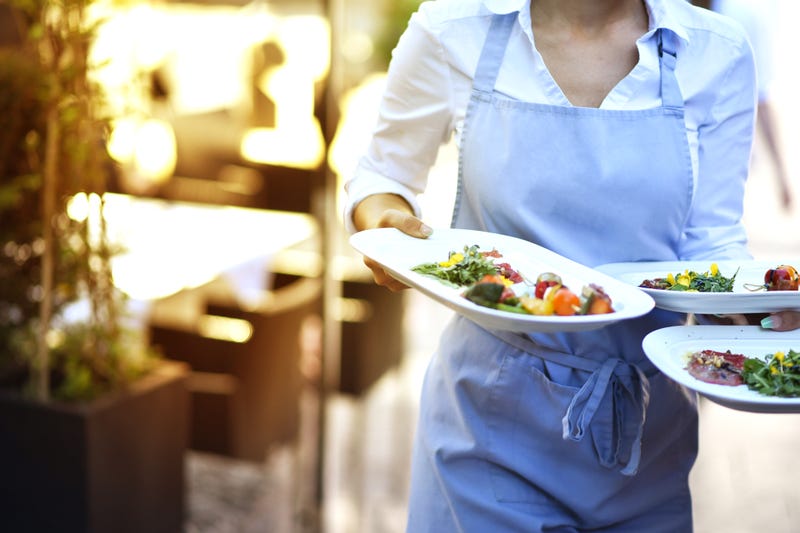 A server delivers food to diners