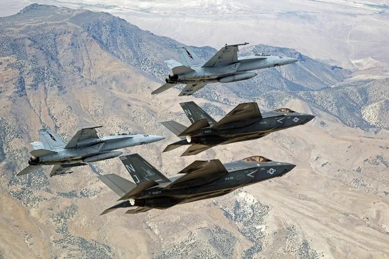 In this Sept. 3, 2015, file photo provided by the U.S. Navy, F-35C Lightning IIs, attached to the Grim Reapers of Strike Fighter Squadron (VFA) 101, and F/A-18E/F Super Hornets attached to the Naval Aviation Warfighter Development Center (NAWDC) fly over Naval Air Station Fallon's (NASF) Range Training Complex near Fallon, Nev