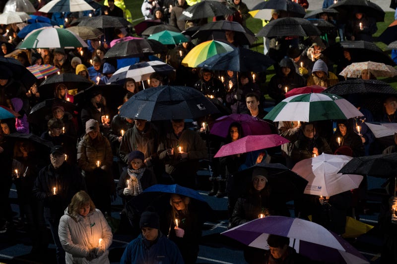 Mourners attend a Feb., 2018 community vigil at Newtown High School for victims of the shooting Marjory Stoneman Douglas High School in Parkland, FL. Rep. Marjorie Taylor Greene (R-GA) has agreed with bogus claims that neither event happened.