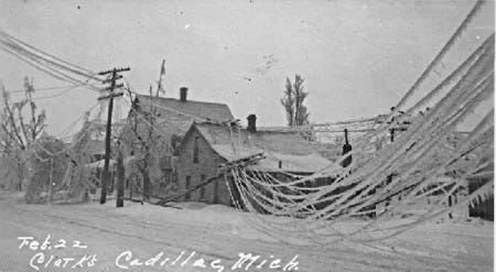 Road in front of Cadillac, Michigan neighborhood during 1922 ice storm. A power pole and lines have been toppled by the ice.