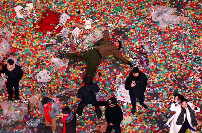 A man lays in confetti following New Year's Eve festivities in Times Square on Jan. 1, 2024.