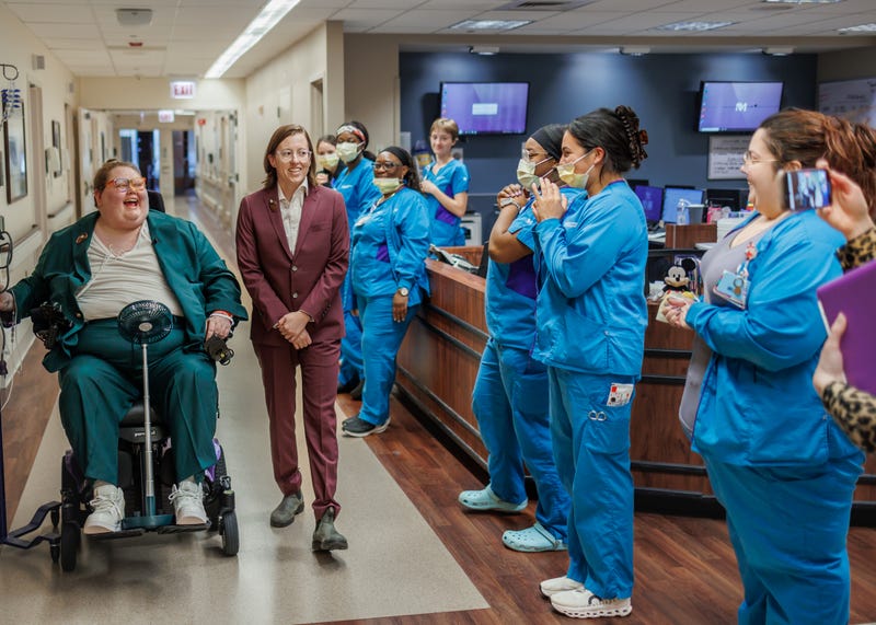 Nurses at Northwestern Hospital cheer on Annesley Clark and Christine Corso as they walk down the aisle for their wedding, which took place inside the hospital — one day before Clark was scheduled to have open heart surgery.