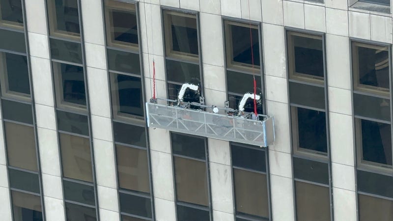 Ozmo is seen cleaning the windows of 1133 Sixth Ave