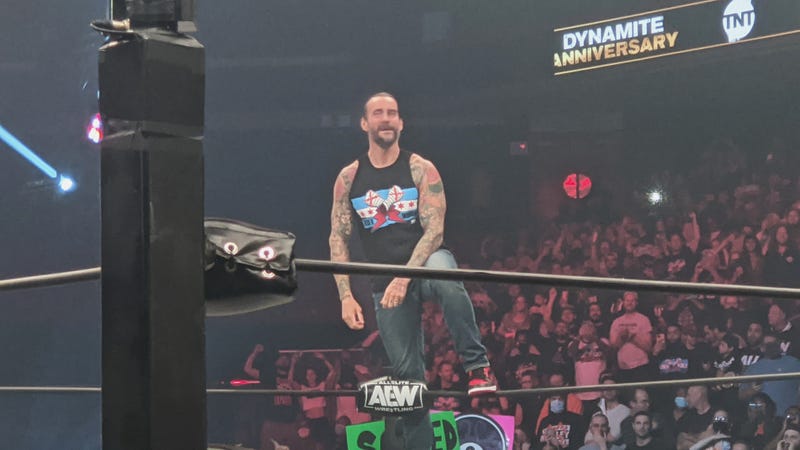CM Punk standing on the top rope at a show