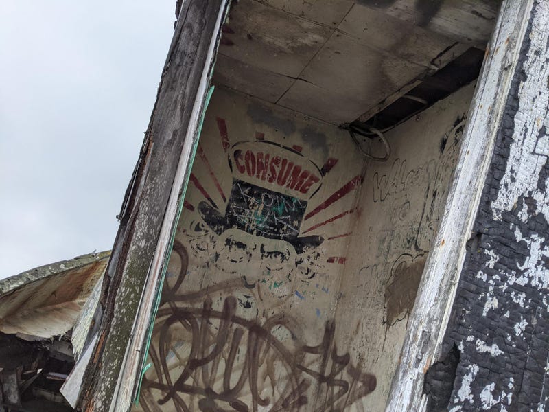 Traces of fire and graffiti scar an open doorway.